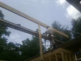 Carpenter setting a ridge beam over a new addition frame — Ice Dam Removal by Roofing Brothers in Fort Morgan