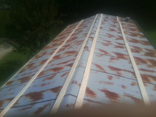 Rusted metal roof panels with new wood purlins before replacement — Storm Damage Roof Repair in Fort Morgan by Roofing Brothers
