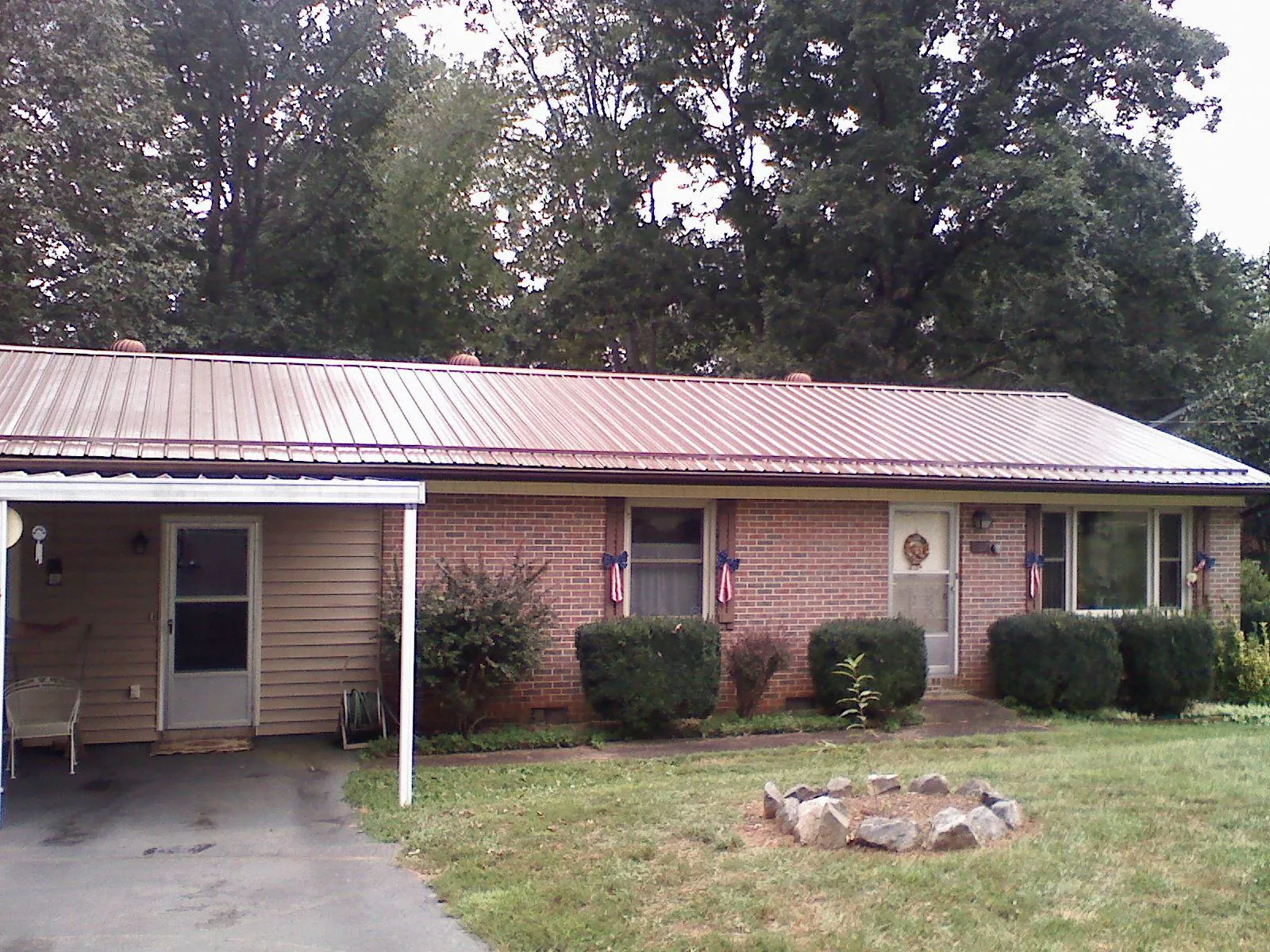 Bronze metal roof and carport on a brick ranch home — Roof Repair work by our crew in Fort Morgan