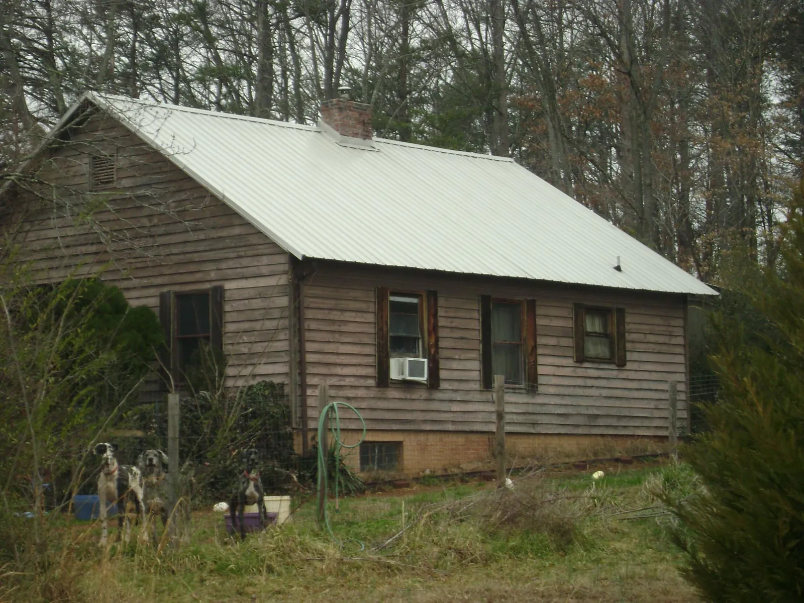 White metal roof on an old wood sided farmhouse, from a Metal Roof Installation job in Fort Morgan